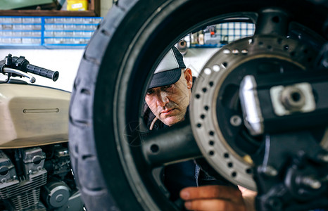 机械修理工在其车间定制摩托车轮选择关注背景机械工修理定制摩托车轮图片