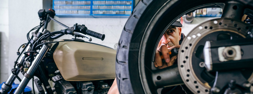 机械修理工在其车间定制摩托车轮选择关注背景机械工修理定制摩托车轮图片