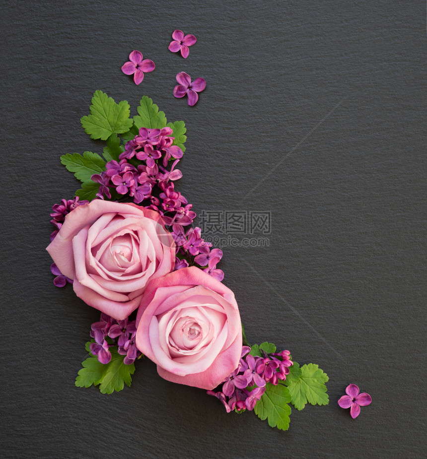 由粉红玫瑰紫花和绿色叶子组成的装饰分在黑板上有复制空间图片