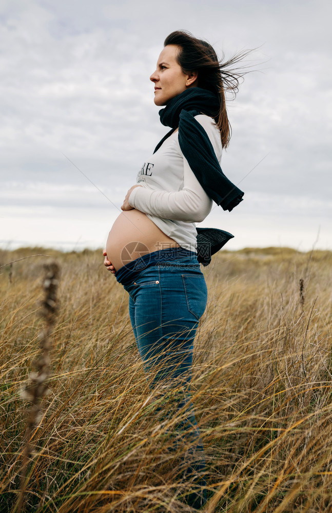 孕妇在田里抚摸她的肚子图片