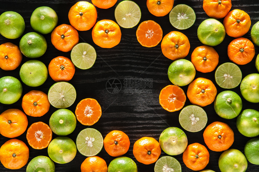 新的全橙子石灰和将黑木本底的水果减半并有复制空间图片