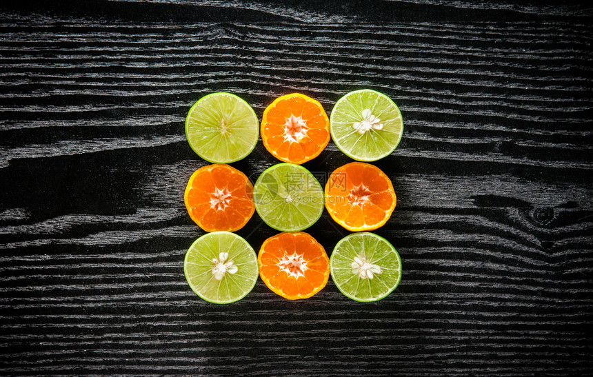 新的全橙子石灰和将黑木本底的水果减半并有复制空间图片