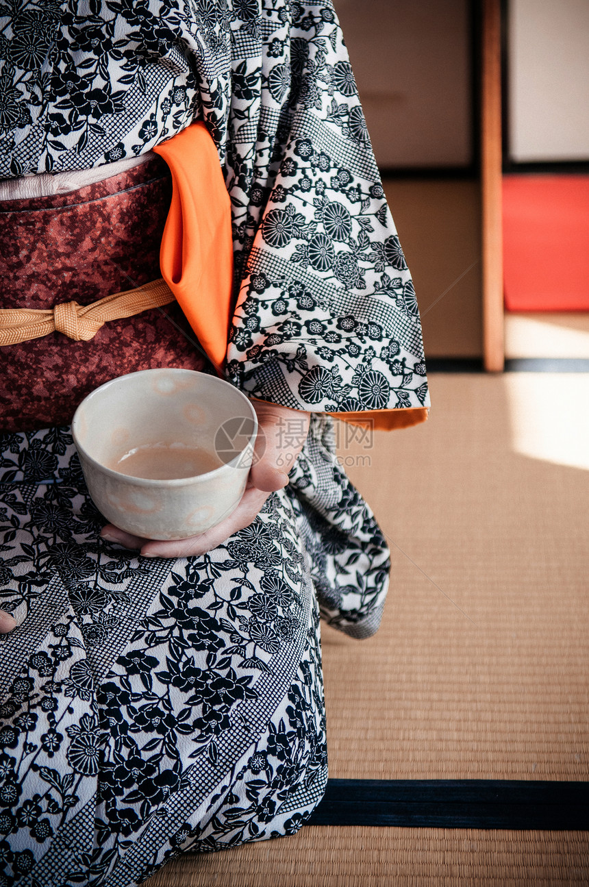 妇女穿着美丽的和服在塔米房间传统的日本火柴茶仪式上拿着杯图片