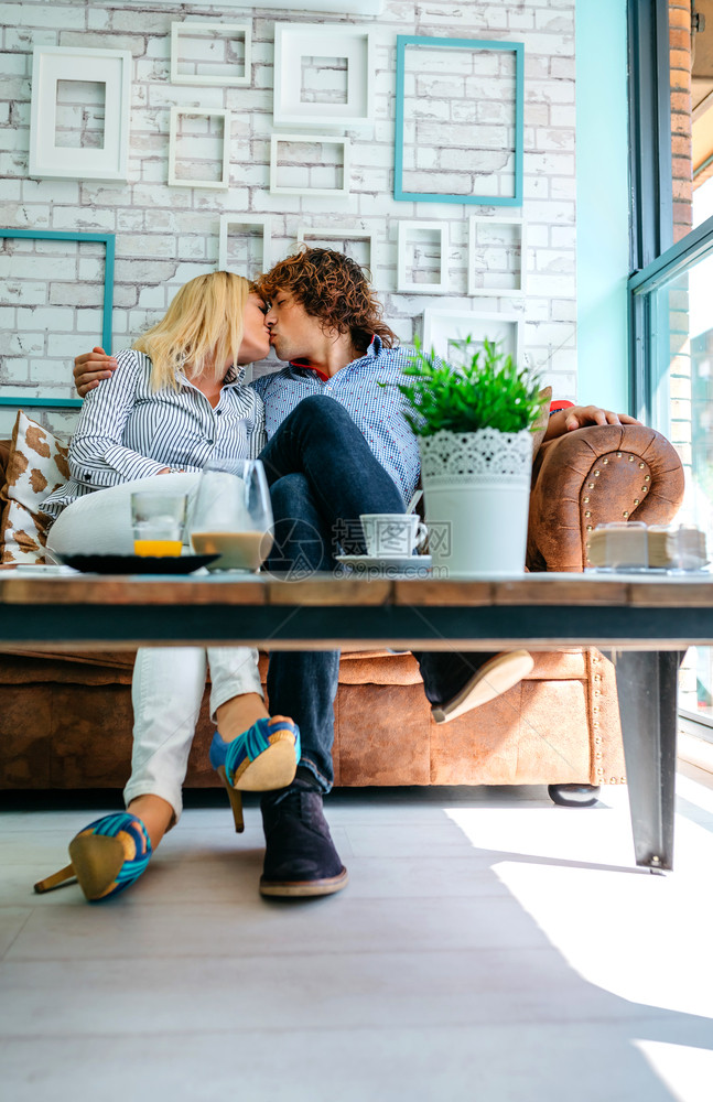 一对夫妇在咖啡店的沙发上亲吻一对夫妇在沙发上亲吻图片