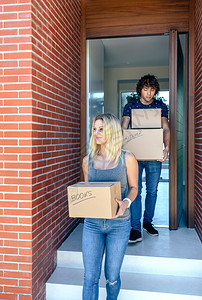 一对幸福的夫妇搬着纸板箱来到他们的新家搬运纸板箱的夫妇图片