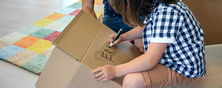 小男孩和父亲在搬家的盒子里写着名字背景