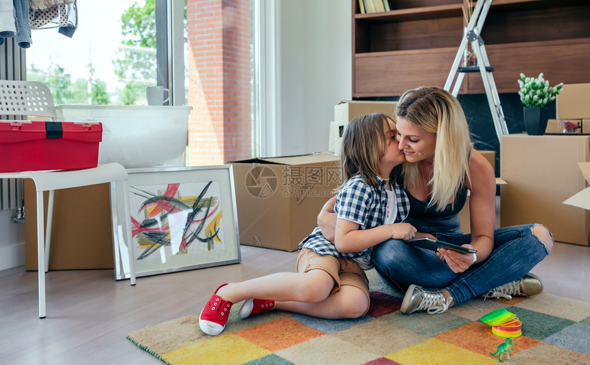 母女两坐在地毯上女儿亲吻着母亲图片