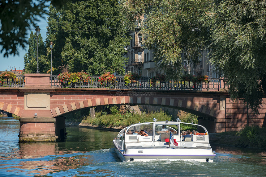 在斯特拉堡的旅游娱乐活动在夏日阳光明媚的一天在古老桥梁和树木下在河水乘船出游在河水不适的地方游览图片