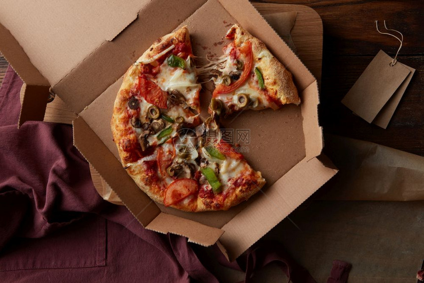 比萨饼概念在木制餐桌上的纸板盒中装有新鲜比萨饼在厨房桌上有美味的比萨饼在纸板上装有新鲜比萨饼图片