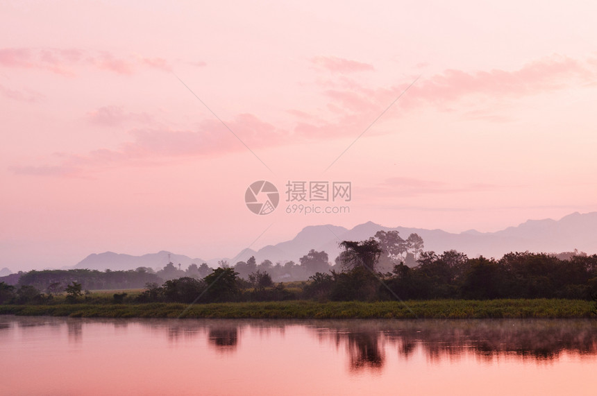 夜晚或清晨美丽的三边风景温暖日落或光山景在平静的河流表面反射图片