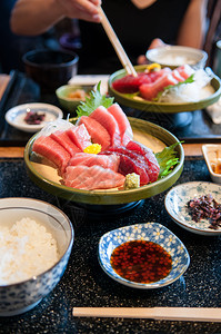 新鲜鲑鱼金托罗马朱托鱼尾生片和餐桌上陶瓷板的黄玉子高清图片