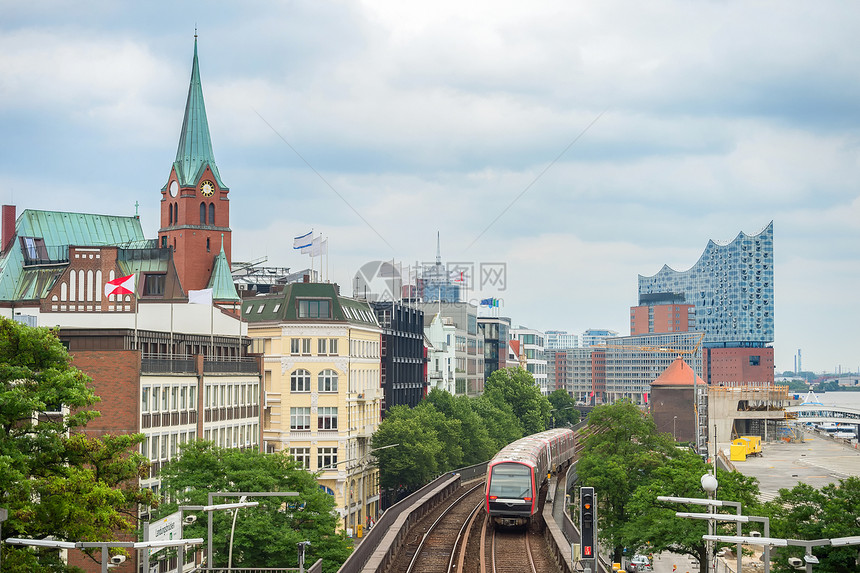 地铁火车经过汉堡的堤岸时钟塔和精灵药店大楼在背景上德国图片