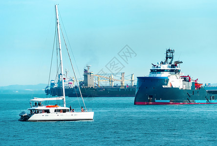 什拉波尔港的货运船和白色游艇图片