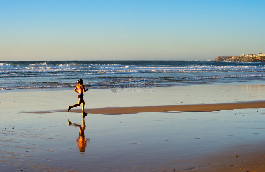 女人在日落时在海边奔跑图片