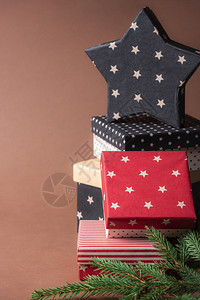 圣诞架圣诞节展示一串红色和黑盒子的架各种设计图案上面是一颗星形的礼物棕色背景的背景