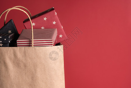 周年店庆促销纸袋里装满了包裹着黑纸和红的礼物色背景的背景