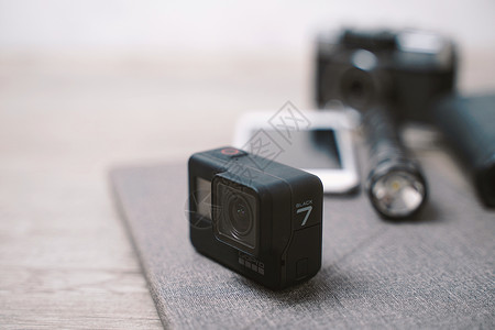 2018年月日新的哥普罗英雄7号黑动作相机配有旅行附件装在木制背景上背景图片