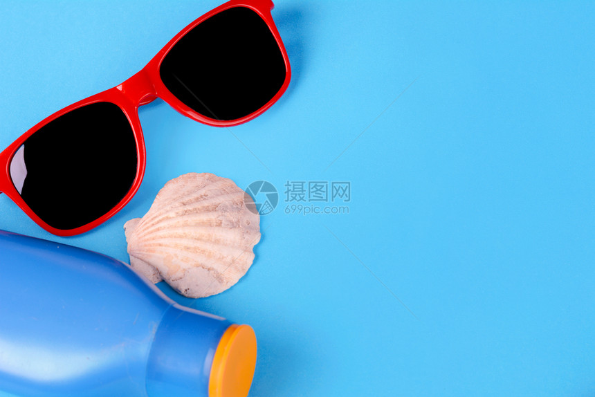 太阳镜贝壳海星和有复制空间的防晒层顶部视图夏季概念浅蓝色背景图片