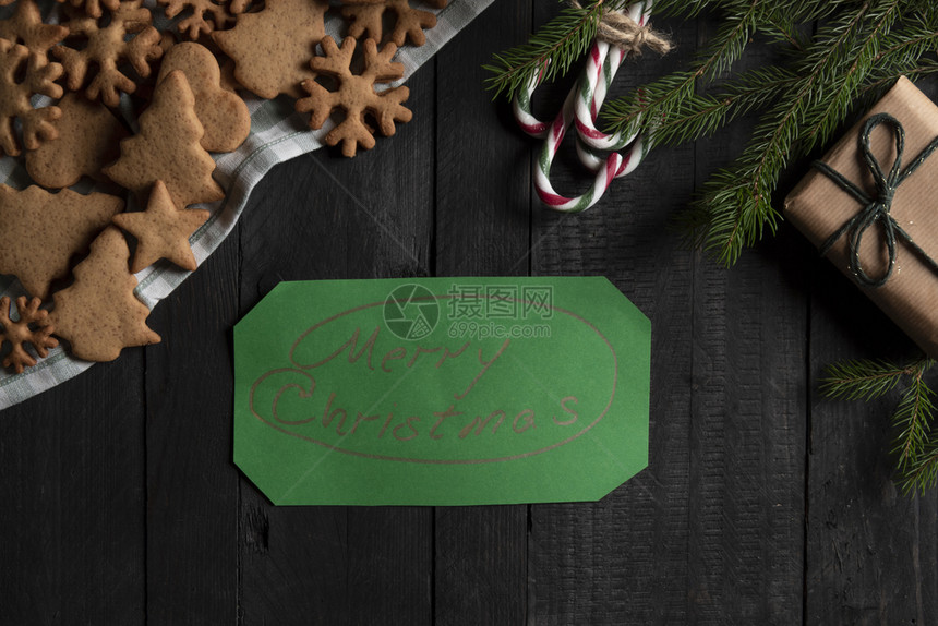 黑色木桌与圣诞甜食礼物盒与绿纸图片