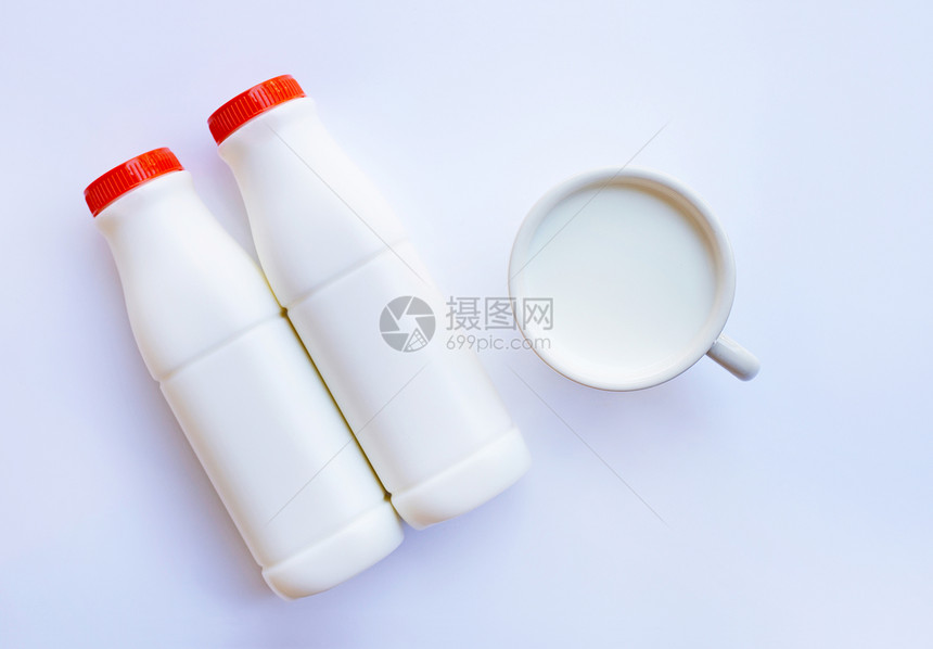 白色背景的牛奶瓶和杯子里的牛奶图片