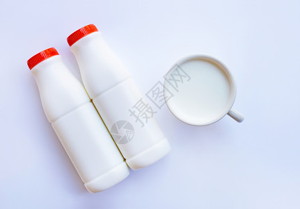 白色背景的牛奶瓶和杯子里的牛奶图片