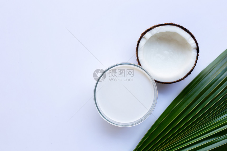 半个椰子和玻璃碗的牛奶图片