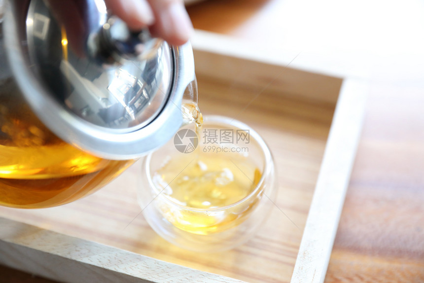 热茶杯在木制桌上加茶壶饮料图片
