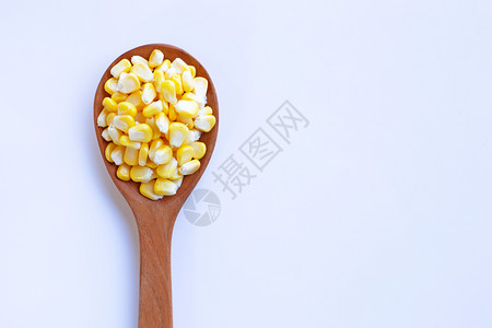 白底木勺子上的玉米种图片