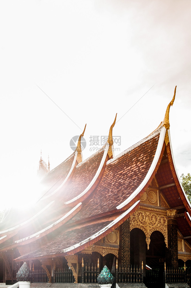 老挝琅勃拉邦阳光下的老挝风格寺庙屋顶图片