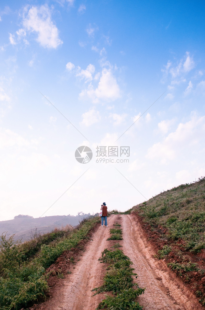 2018Chiangmthlnd年轻女在日落傍晚时山上走泥土路乡村道图片