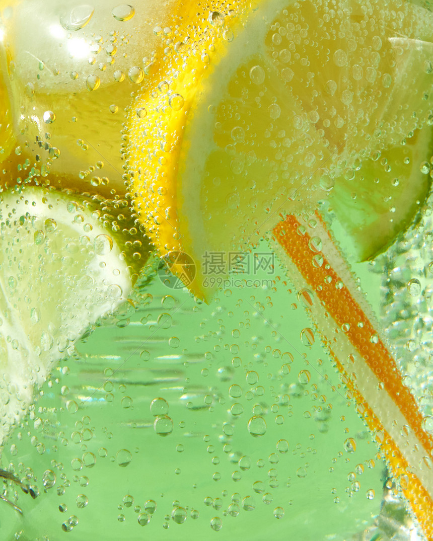 玻璃瓶中气泡玻璃罐中闪亮的新鲜柠檬和片薄荷叶绿色背景的空气泡沫图片