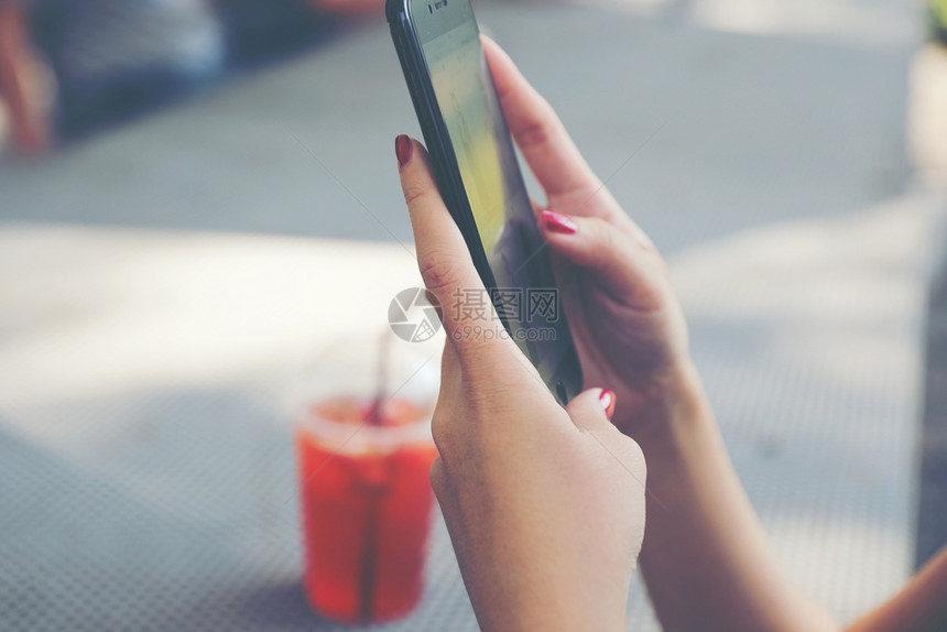 在户外咖啡店网上拥有智能手机交易股的女商业概念图片