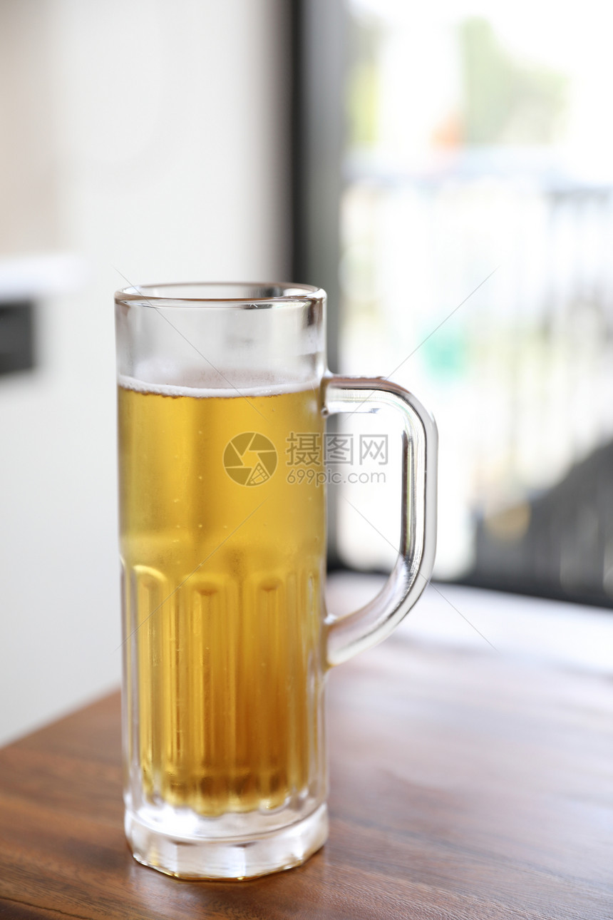 在木本底的高玻璃杯啤酒图片