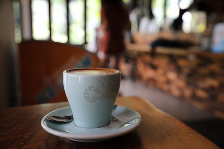 卡布奇诺或拿铁咖啡用店木桌的牛奶制成咖啡图片