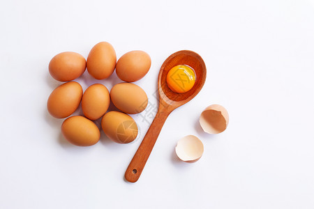 勺子上的蛋黄和旁边的八个鸡蛋图片
