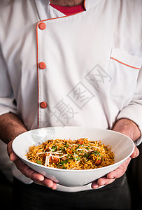 男厨师拿着两只手的鸡肉briyan饭碗近镜头高清图片