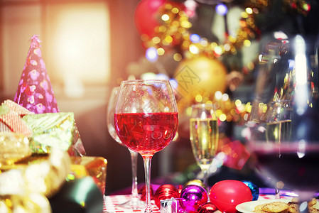 红香槟杯和礼物盒派对配件模糊的bokeh光背景圣诞快乐和新年庆典概念图片