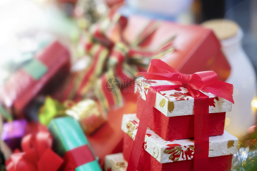圣诞快乐背景概念关闭红礼盒在背景中模糊了另一个礼物盒图片