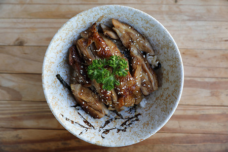 照牙镜日本料理鸡肉照yoki和木片背景上的米饭背景