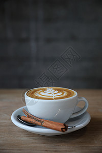 卡布奇诺咖啡或拿铁艺术由店木桌上的牛奶制成图片