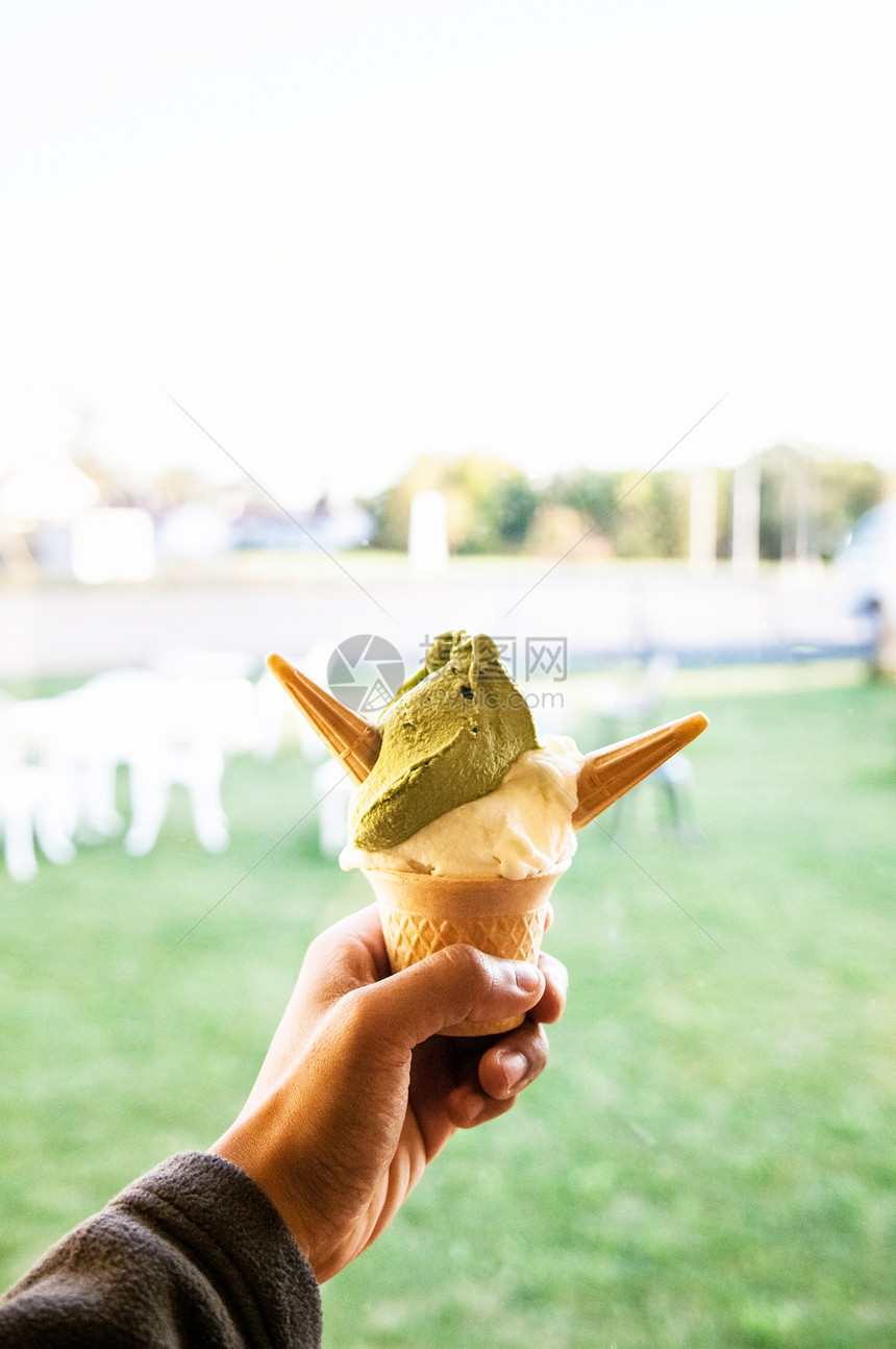 手头有一杯绿色茶红冰淇淋软奶油图片