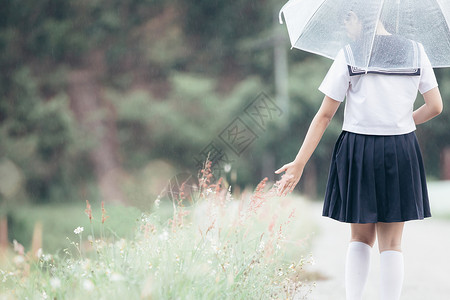 白色雨伞下雨时在自然行走道上带着雨伞行走的亚裔女学生肖像背景