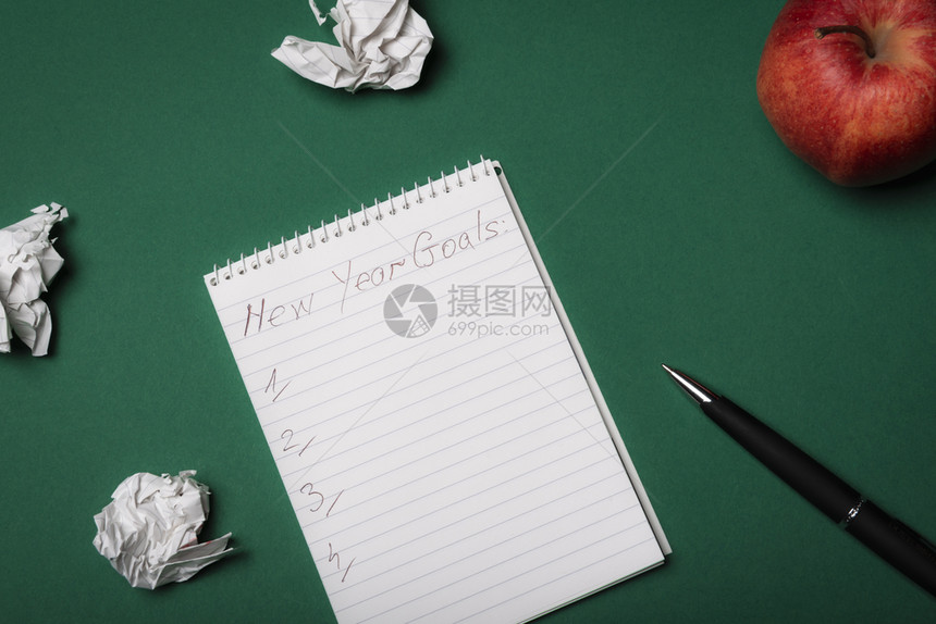 新的一年决议清单由折叠纸和苹果环绕图片