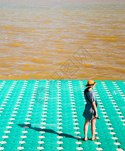 亚裔女站在多彩的漂浮码头河泰图片