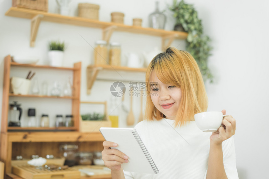 女子一边记录一边喝咖啡图片