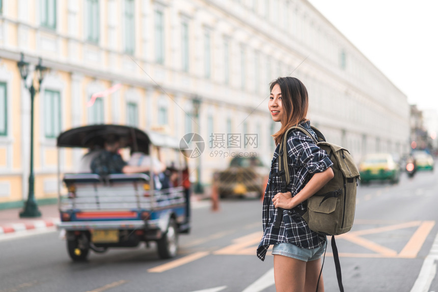 快乐的年轻女在惊人的地标度假享受传统城市的旅程图片