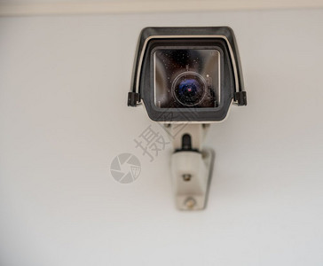 在墙上安装的白色摄像全头前方的白色摄像头直视观看者现代监控摄像头图片