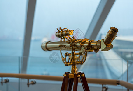 游船甲板上观望窗外的巡航船用光学黄铜望远镜图片