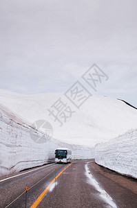 日本雅潘的公交行驶于雪墙之间道路视图图片