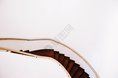 古老的木螺旋楼梯扶手和大白墙空间背景图片
